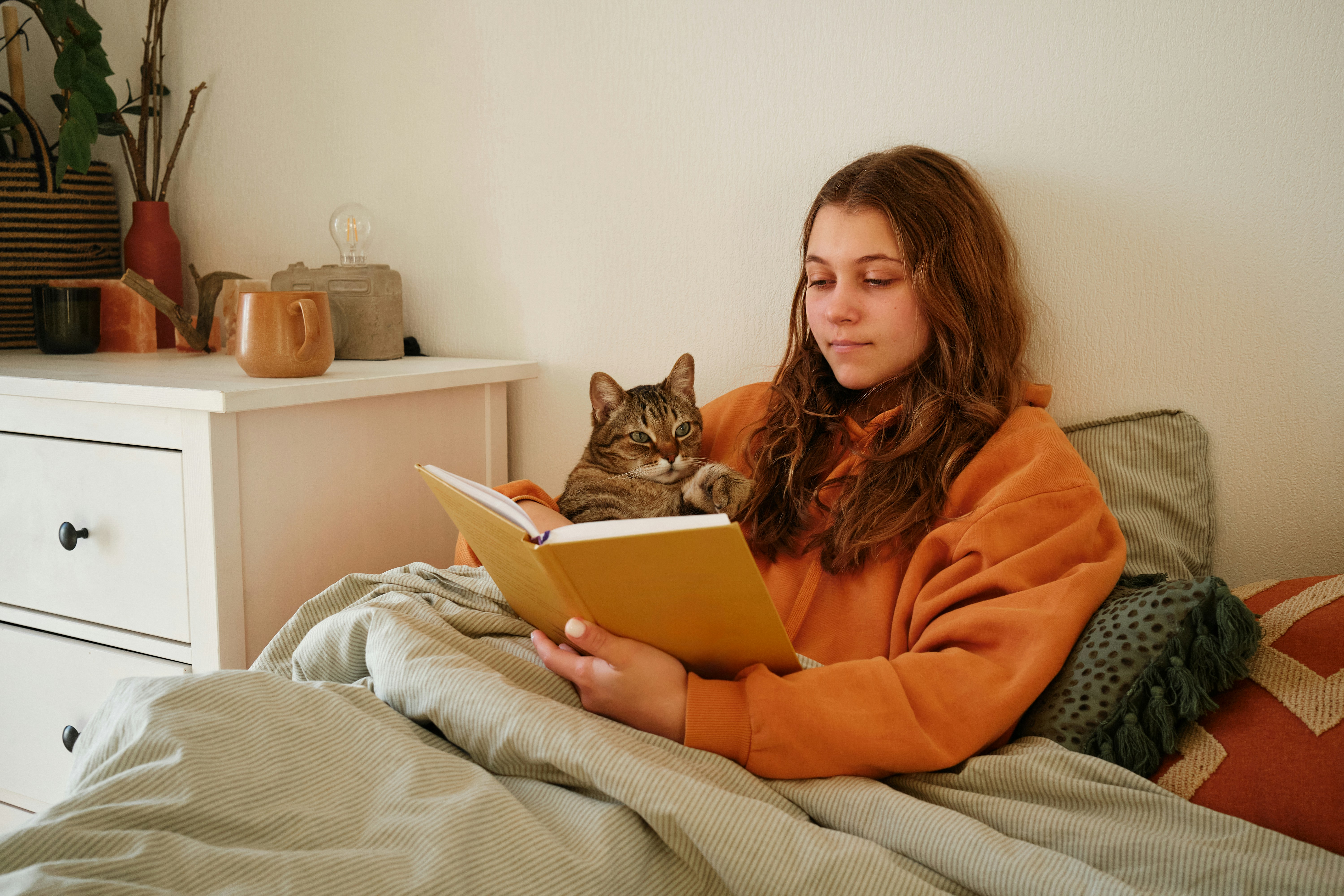 woman reading in bed as part of a relaxing bedtime routine