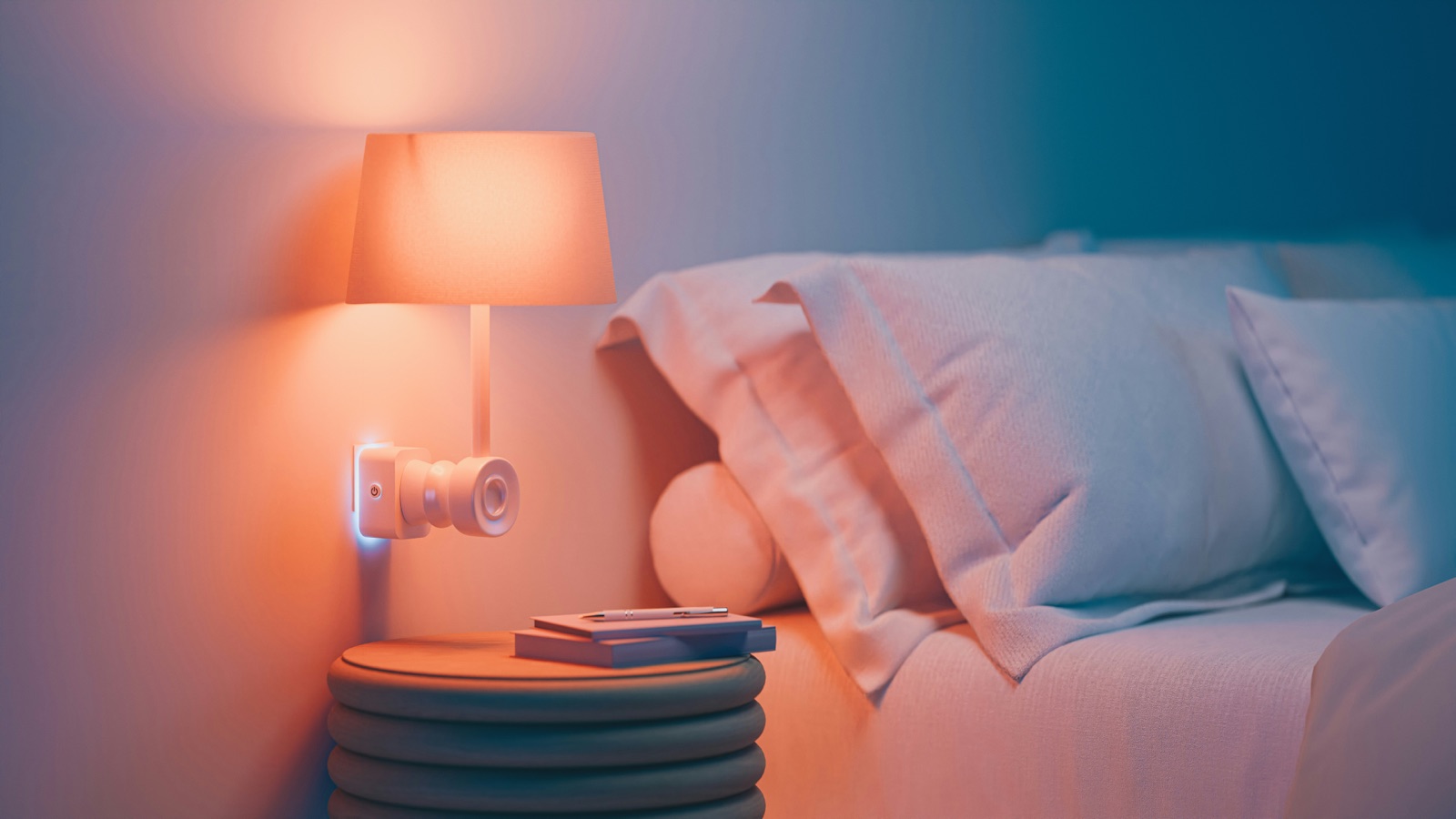 bedside device beside a warm lamp and pillows in a softly lit bedroom