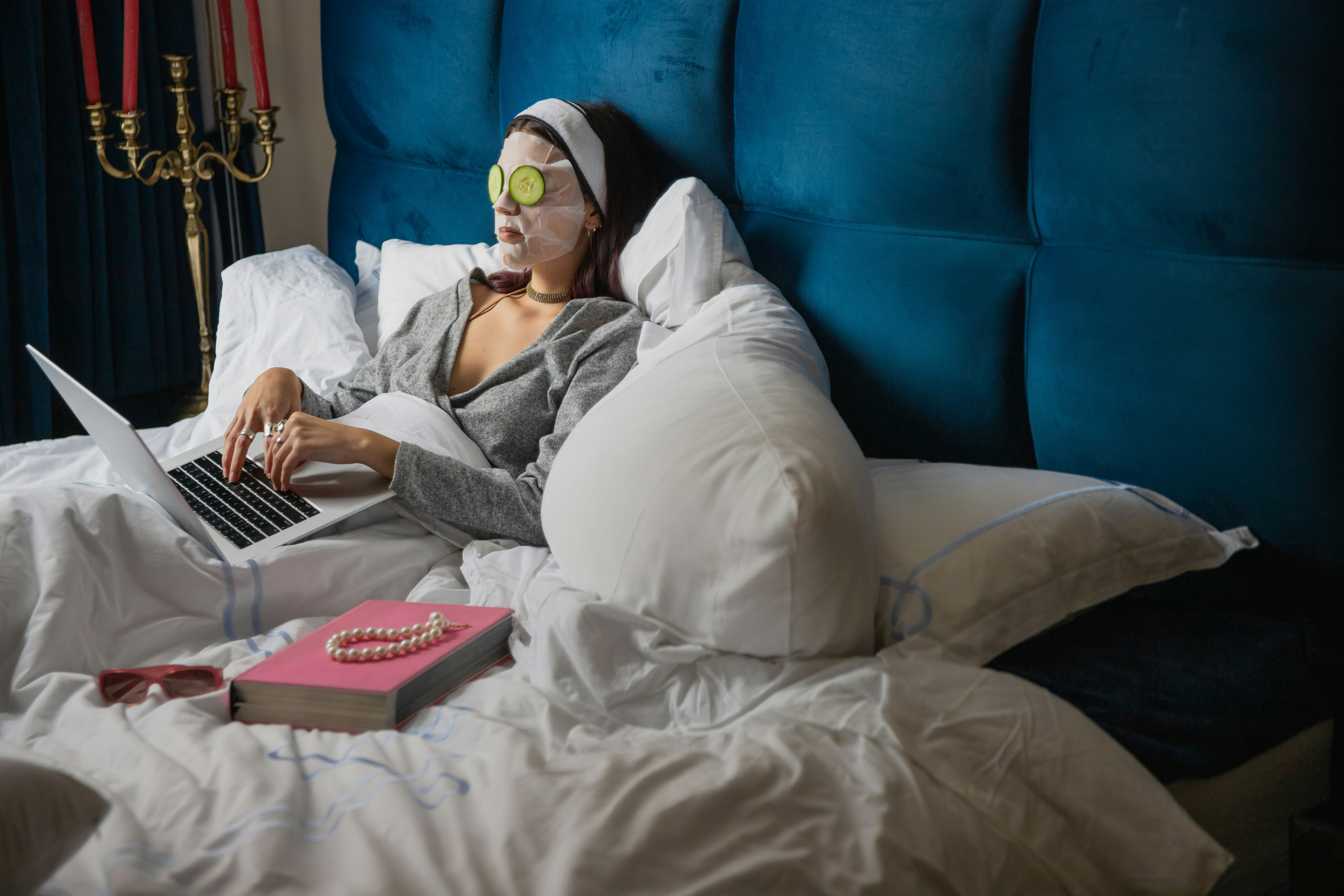 woman wearing a facial mask and using a laptop in bed before bedtime