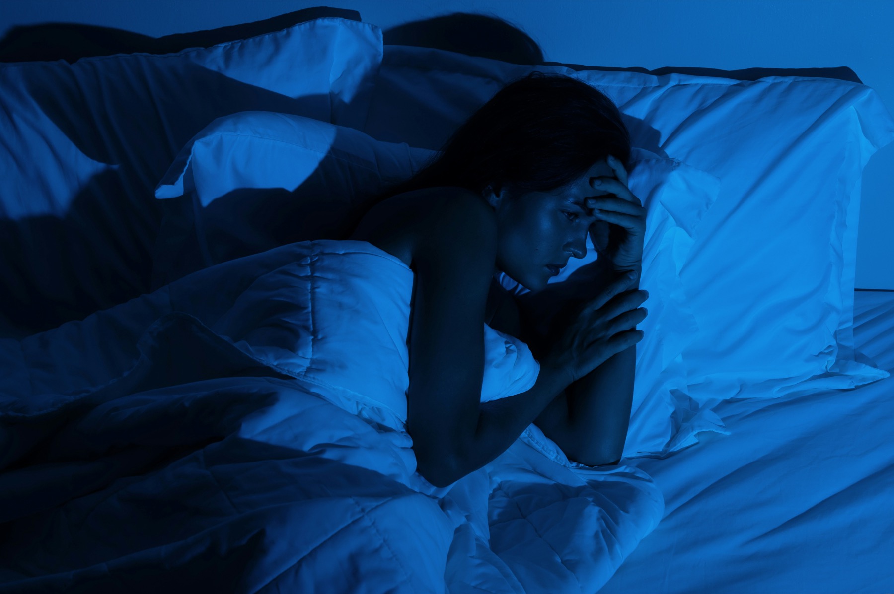 person awake in bed wondering why do i wake up at 3am