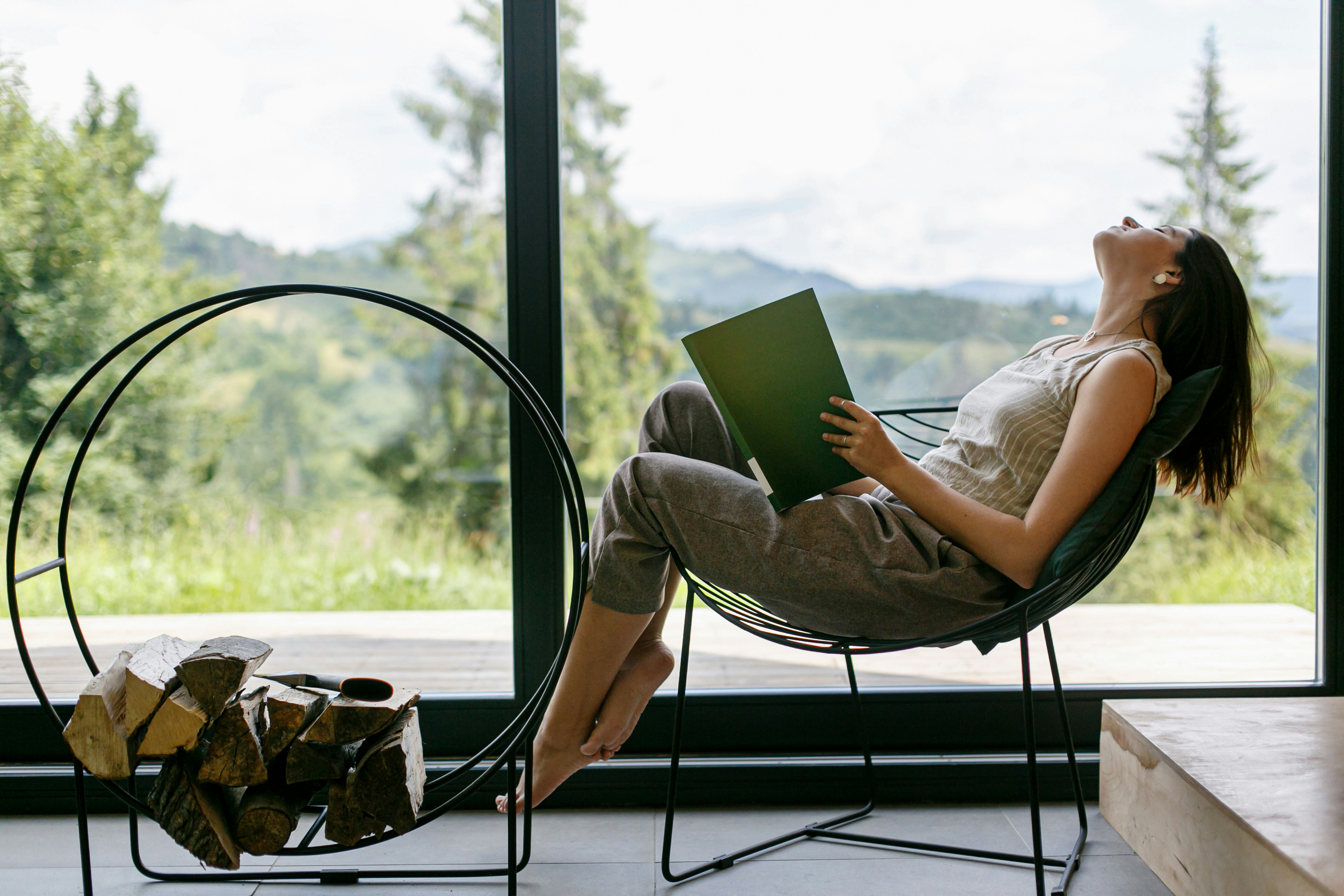 A woman reclining with a book during a quiet daytime break, illustrating nap timing and sleep pressure