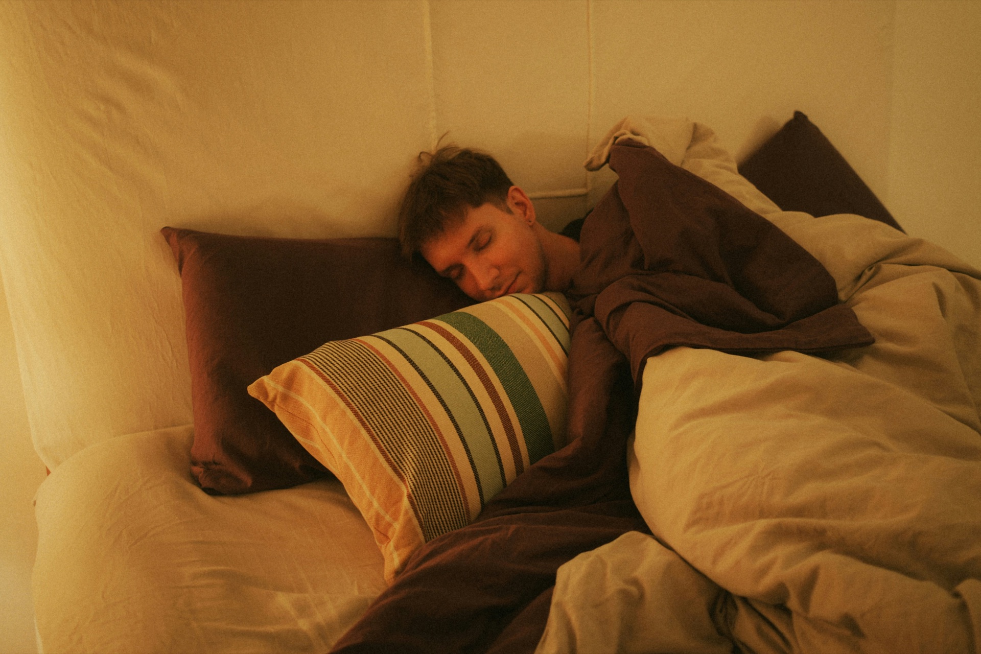 A person resting on their side under a duvet, illustrating a guide to micro-awakenings during sleep